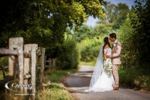 bride and groom kiss down a country lane at gate street barn